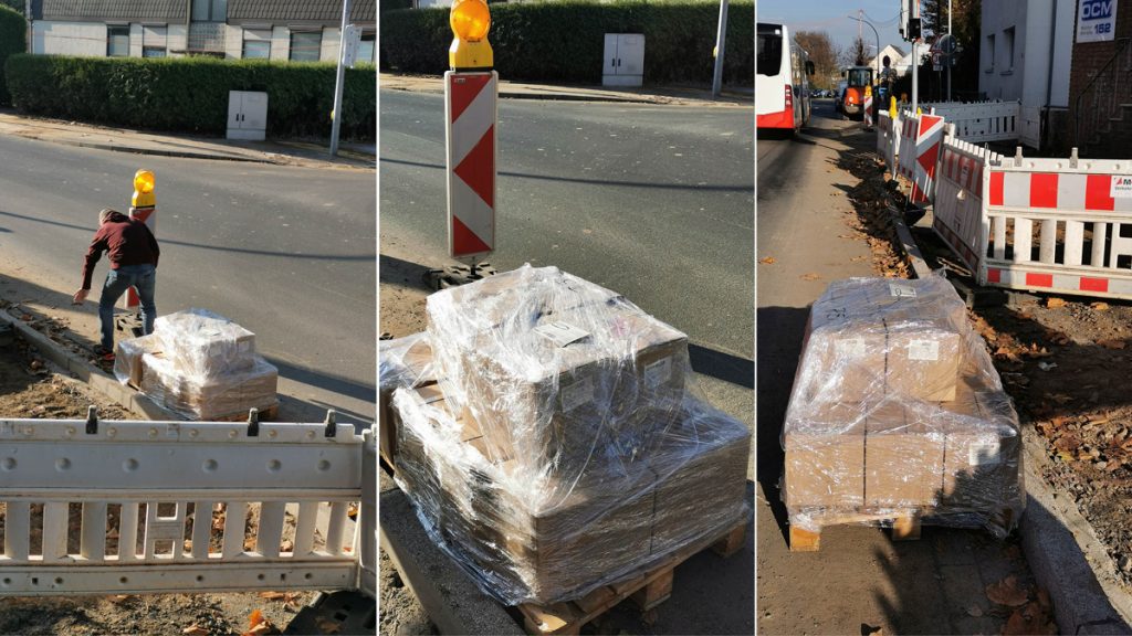 Eine Palette mit Büchern steht in der Baustelle vor dem Verlag.