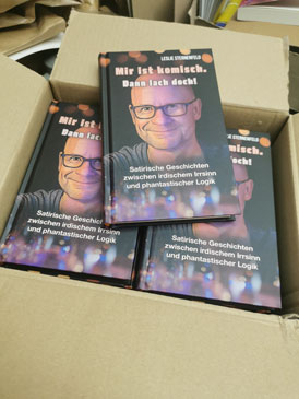 Der ge;ffnete Buchkarton mit der Neuerscheinung „Mir ist komisch. Dann lach doch!“ von Leslie Sternenfeld.